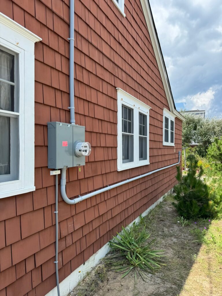 Electrical box with pipes mounted in the wall of a house.